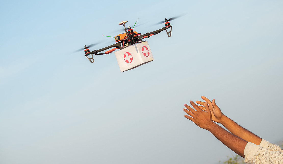 Drone Delivering First Aid Box or medicine to costumer hand during covid-19 or coronavirus lockdown - Advancing Medical Industry Logistics for Drug Transport concept.