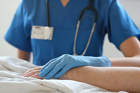 A young doctor examines an elderly patient.
