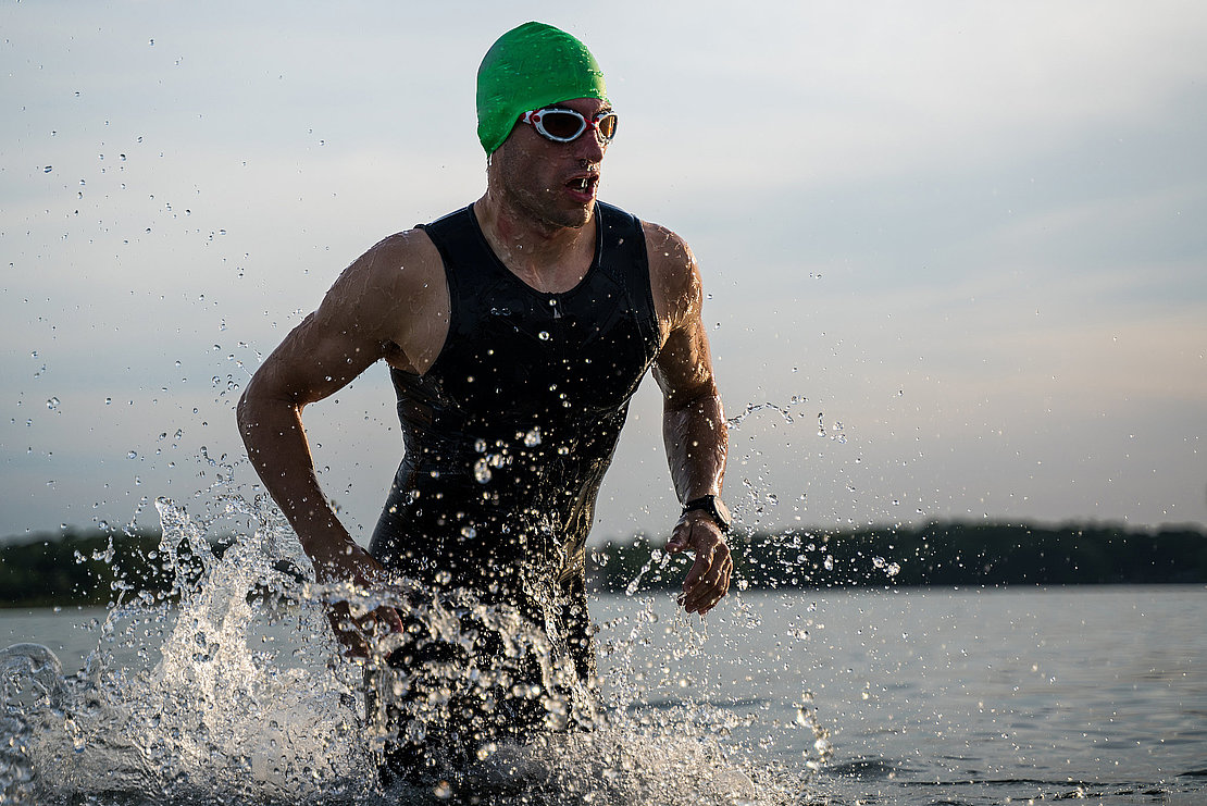 The triathlete runs out of the water. Swimming training.