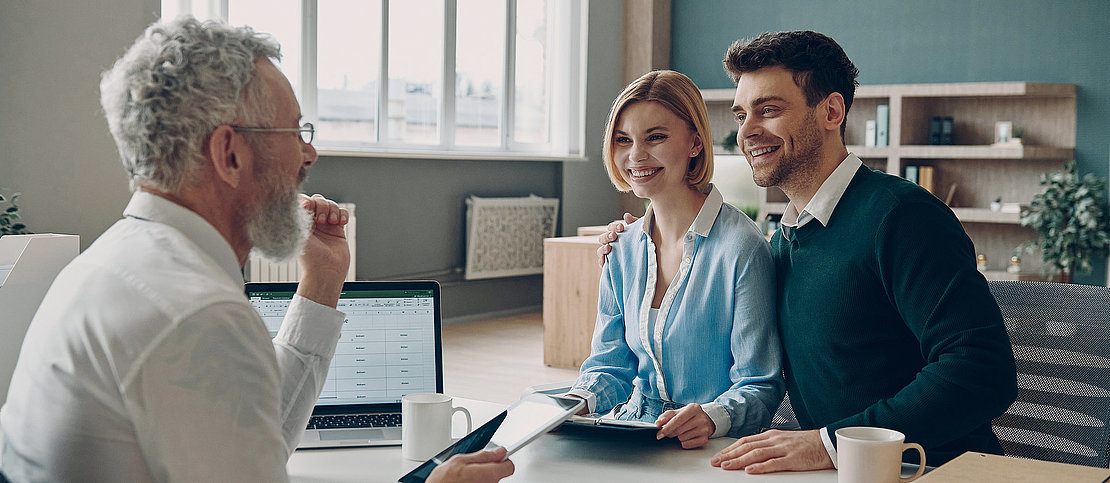 Financial advisor using digital tablet while explaining something to his clients in the office