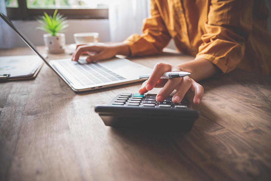 business person sitting at a desk at an office By using the calculator to work. Business Concept Analysis and Planning