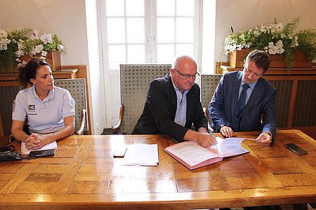 Jean-François Irigoyen, maire de Saint-Jean-de-Luz, signant la convention en compagnie de Jérôme Bourrier, procureur de la République de Bayonne. Photo © Ville de Saint-Jean-de-Luz