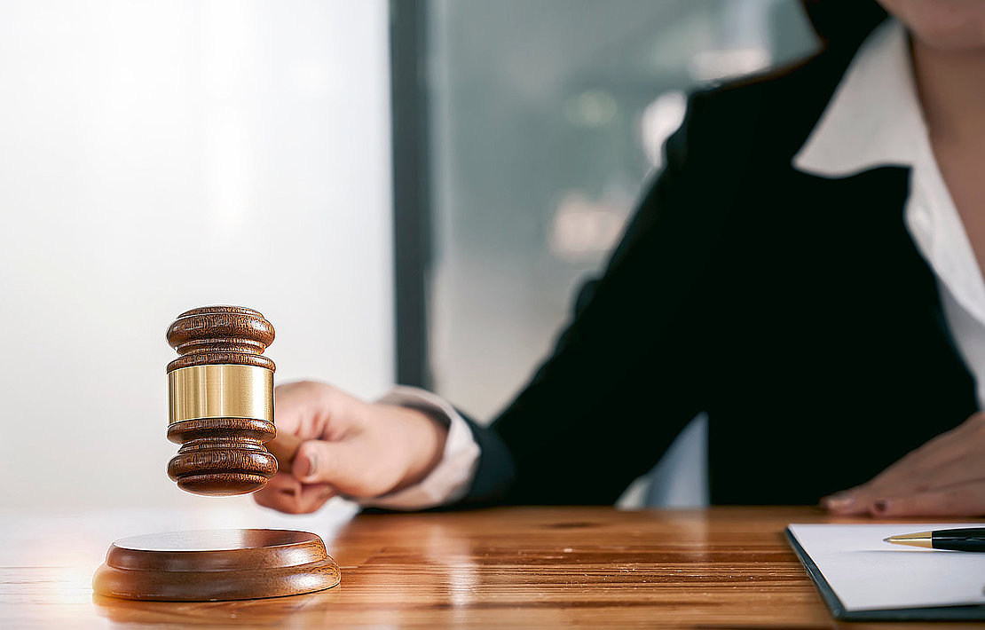 Woman judge hand holding gavel to bang on sounding block in the