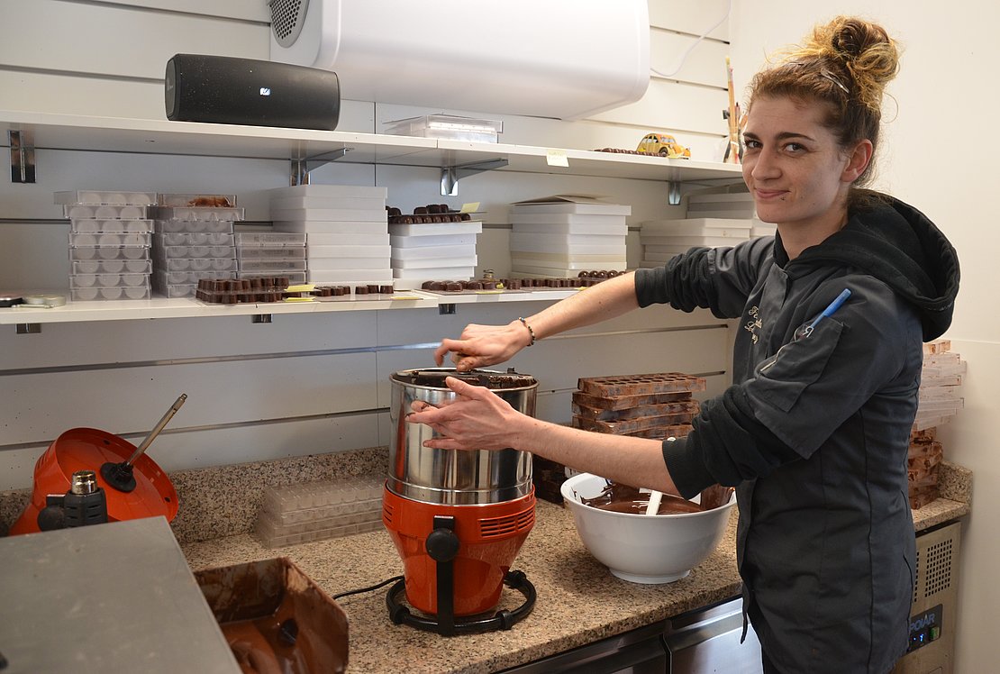 Léa Vazquez travaille le chocolat dans son atelier, juste à côté de la boutique - Photo © JP