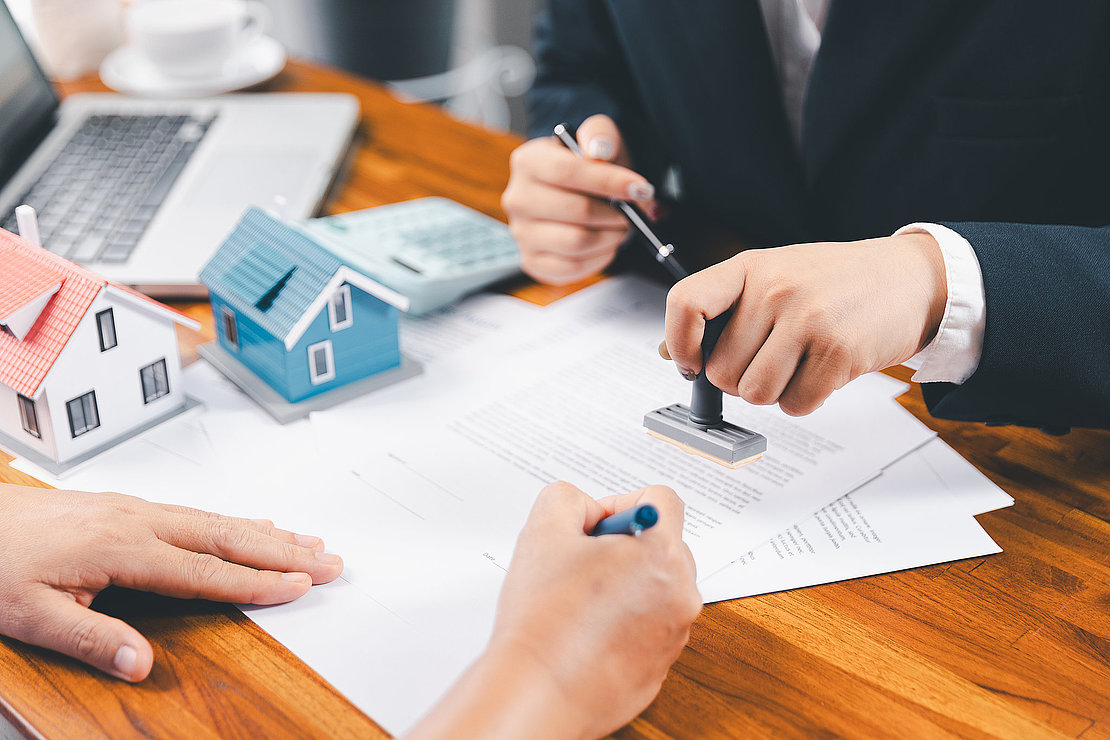 Bank approve loan to buy home concept. Real estate agent talked about terms of home purchase agreement, asked customer to sign documents to make contract legally. approved mortgage application form.