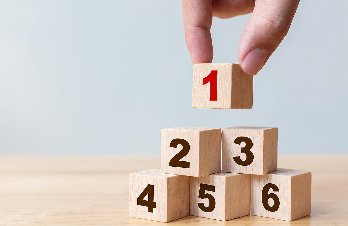 Hand arranging wood block stacking as step stair with number. Th