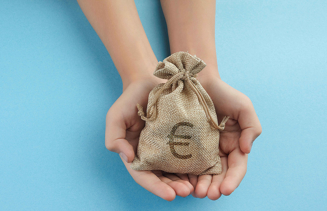 Women hold a money bag on blue background, Saving money for future investment concept.