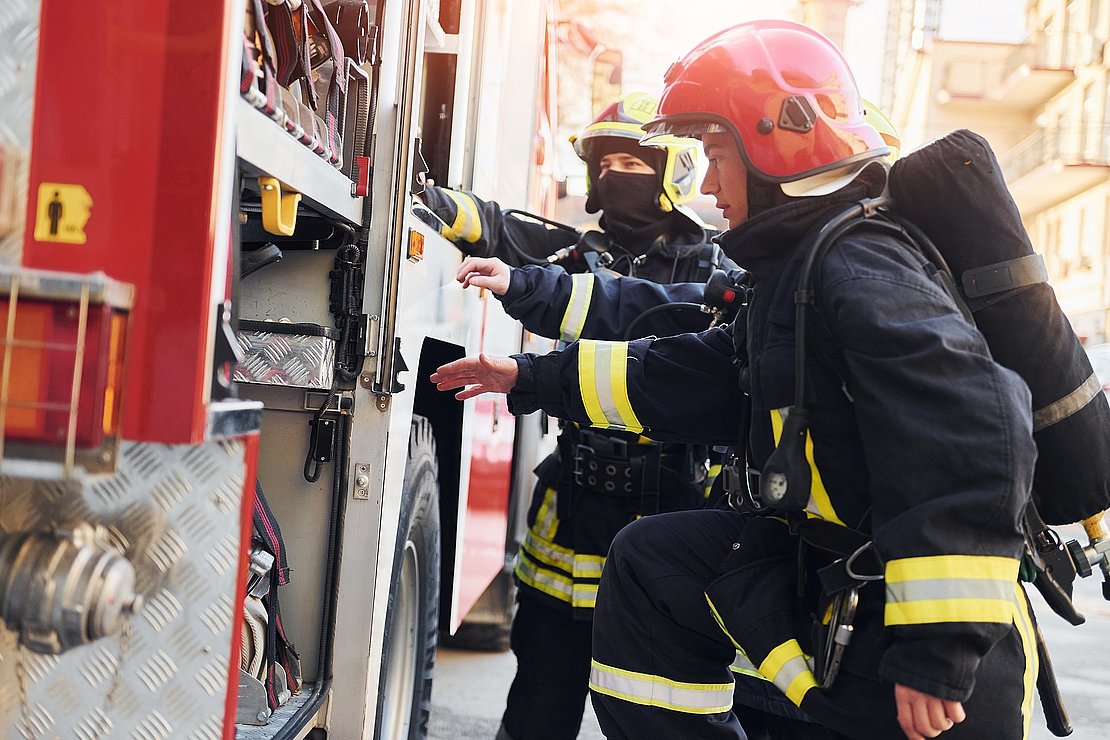 Group of firefighters in protective uniform that outdoors near t